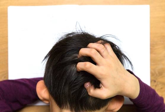 학생이 공부가 잘 않풀려 머리를 긁적거리는 모습