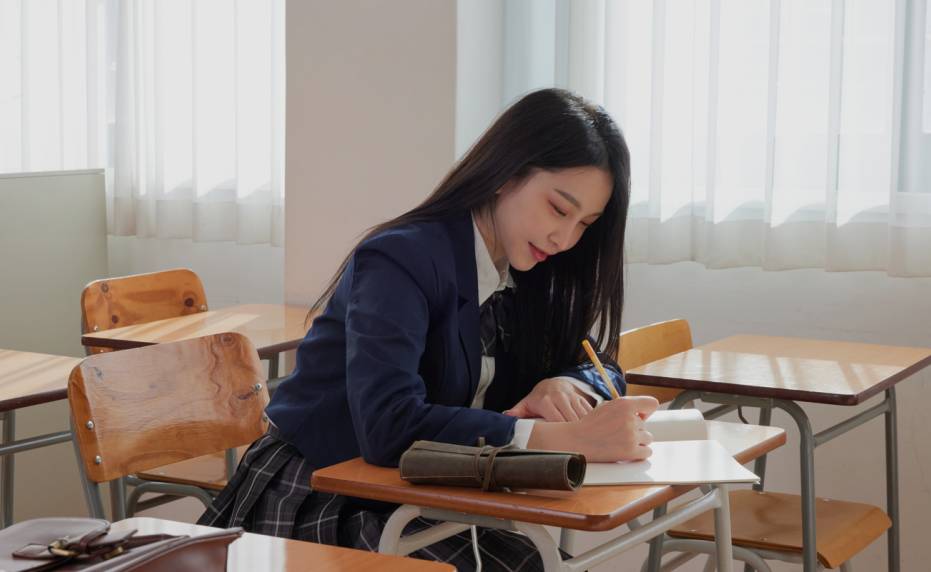 학원 책상에 않아 영어 공부를 하고 있는 여학생 모습